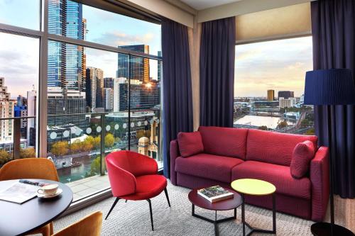 a living room with a red couch and a large window at DoubleTree by Hilton Melbourne in Melbourne