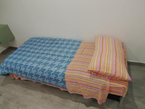 a bed with a striped blanket on top of it at La casa di Teresa in Taranto