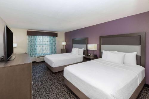 a hotel room with two beds and a flat screen tv at La Quinta by Wyndham Rockwall in Rockwall