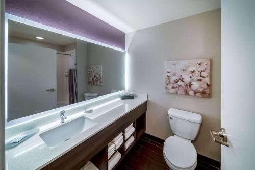 a bathroom with a sink and a toilet and a mirror at La Quinta by Wyndham Rockwall in Rockwall