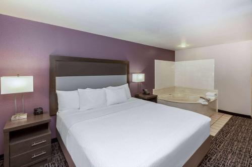 a bedroom with a large bed and a bath tub at La Quinta by Wyndham Rockwall in Rockwall