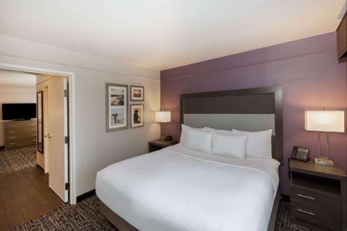 a large bed in a hotel room with purple walls at La Quinta by Wyndham Rockwall in Rockwall