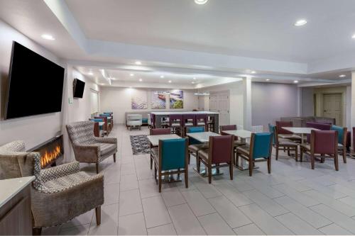 a restaurant with tables and chairs and a fireplace at La Quinta by Wyndham Rockwall in Rockwall