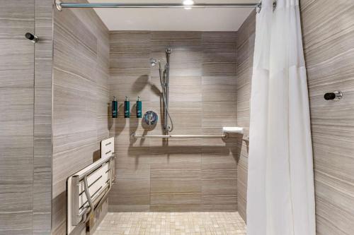 La salle de bains est pourvue d'une douche et d'un rideau de douche. dans l'établissement Hilton Club The District Washington DC, à Washington
