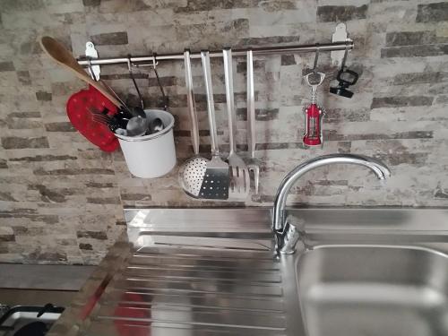 a kitchen counter with a sink and utensils at La casa di Teresa in Taranto