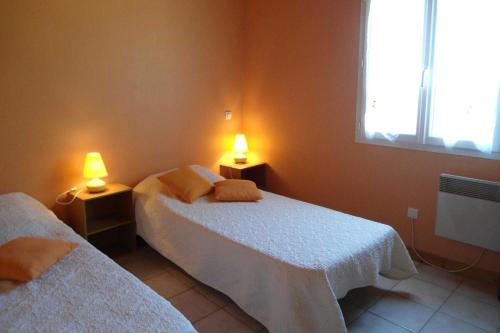 dwa łóżka w pokoju z dwoma lampami w obiekcie Les charmes en périgord noir proche de Sarlat w mieście Paulin
