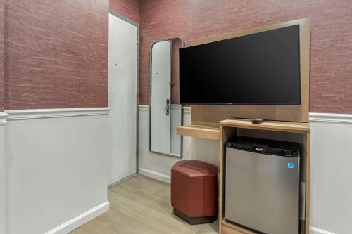 a room with a flat screen tv on a wall at The Historic Mayfair Hotel Times Square, Ascend Hotel Collection in New York
