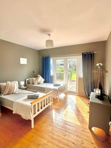 a bedroom with two beds and a living room at The Surf House (Widemouth Bay) in Bude