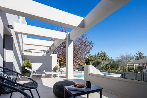 a patio with a table and chairs and a pool at Akonizia Luxury House - With Private Heated Pool and Jacuzzi in Dhrámia