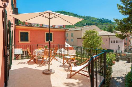 a patio with a table and an umbrella at PORTOVECCHIO Plus in Levanto
