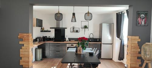 une cuisine avec une table et un réfrigérateur dans l'établissement maison Loupaumaga 2 appartements, à Luchon