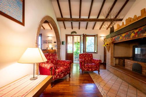 a living room with two chairs and a fireplace at Agriturismo La Casetta del Sole in Villastrada