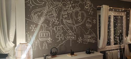 une salle de bains avec un mur recouvert de graffitis dans l'établissement maison Loupaumaga 2 appartements, à Luchon