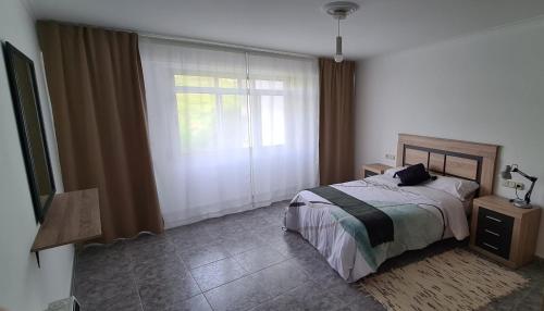 een slaapkamer met een bed en een raam bij Vento Nordés in Malpica