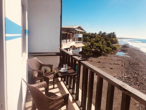 a balcony with chairs and a table on the beach at Warm sunset, Loft by the sea in La Libertad