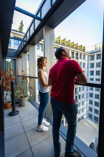 a man and a woman looking out of a window at The People - Paris Marais in Paris