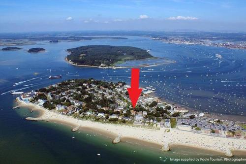 an island in the water with a red arrow at Spacious Sandbanks Apartment near Beach and Bars with Free Parking in Poole