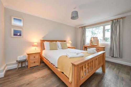 Un dormitorio con una cama grande y una ventana en Spacious Sandbanks Apartment near Beach and Bars with Free Parking, en Poole