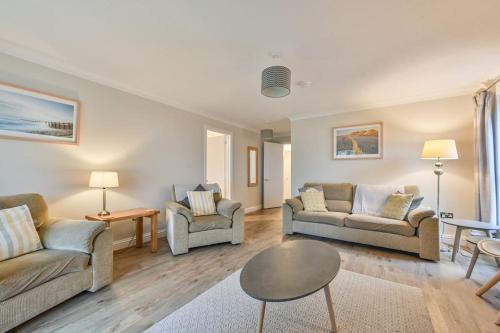 Sala de estar con 2 sofás y mesa en Spacious Sandbanks Apartment near Beach and Bars with Free Parking, en Poole