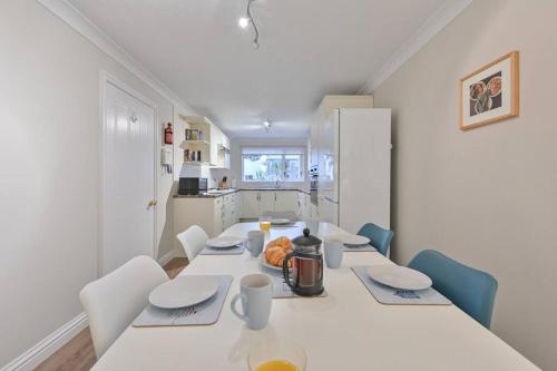 a white dining room with a white table and chairs at Spacious Sandbanks Apartment near Beach and Bars with Free Parking in Poole