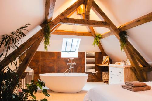 een badkamer met een groot bad op de zolder bij Le Laurencin Sens - Le Duplex in Sens