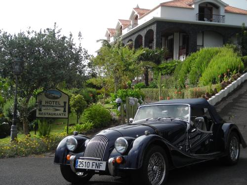 an old black car parked in front of a house at Hotel La Palma Romántica in Barlovento