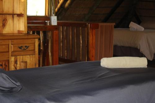 a bedroom with a bed with a towel on it at Emahlathini Guest Farm in Piet Retief
