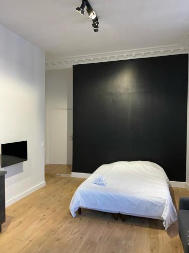 - une chambre avec un lit et un mur noir dans l'établissement Studio Grand Rex, à Paris