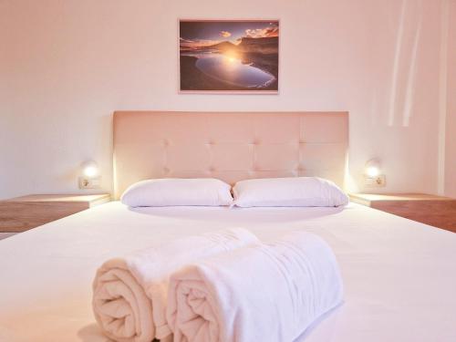 a bedroom with a white bed with white sheets at MEDANO4YOU Brisas Del Atlantico in El Médano