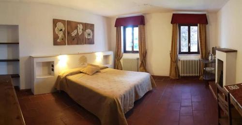 a bedroom with a bed and two windows at AC Ranch in Carentino