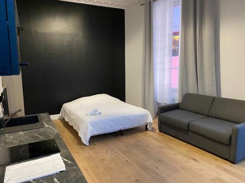 a living room with a bed and a couch at Studio Grand Rex in Paris