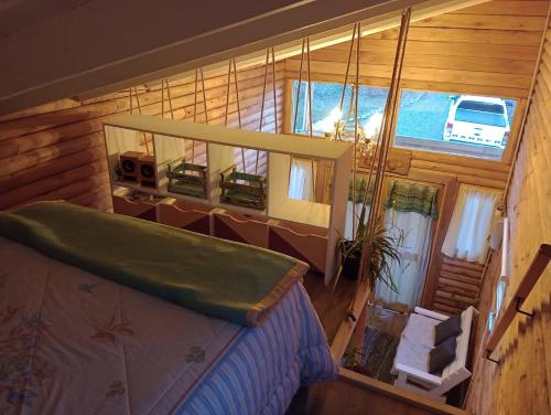 1 dormitorio con 1 cama en una habitación con ventana en Mini Casa de Troncos en el Sur en San Martín de los Andes