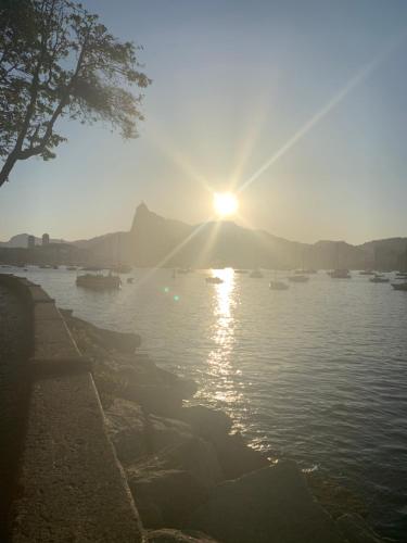 una puesta de sol sobre un cuerpo de agua con barcos en Apê Minimalista Melhor do Centro Self check-in, en Río de Janeiro