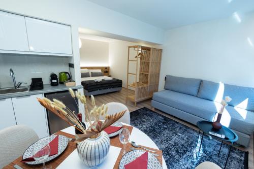 a living room with a table and a blue couch at Athens Airport Living spaces in Spáta