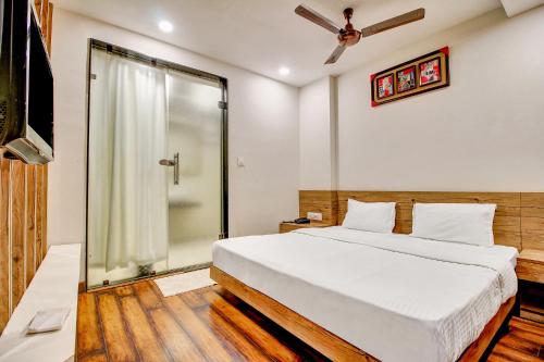 1 dormitorio con 1 cama y ducha acristalada en FabHotel Manjeet en Bhopal