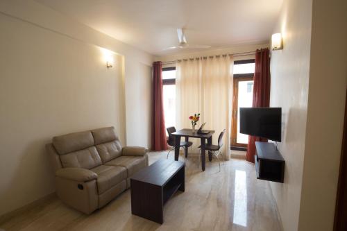 a living room with a couch and a table at Ixora Suites in Bengaluru