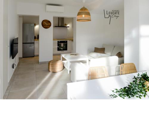 Il comprend un salon avec un mobilier blanc et une cuisine. dans l'établissement Résidence Leucate Plage « Le Patio », à Leucate