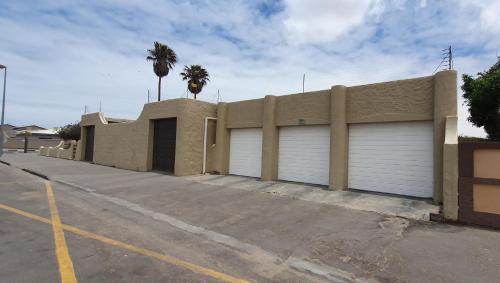 a building with two garage doors in a parking lot at DESERT DREAMS B&B in Walvis Bay