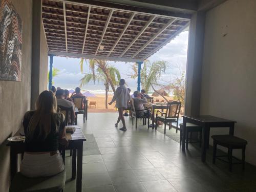 un groupe de personnes assises à table dans un restaurant dans l'établissement Talalla Bay Beach, à Talalla South