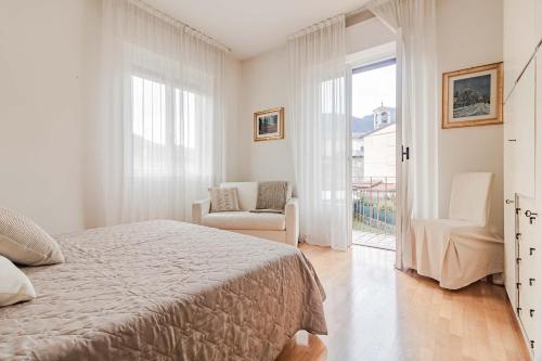 1 dormitorio con 1 cama, 1 silla y 1 ventana en Il lago di Diana, en Mandello del Lario