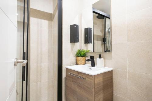 un baño con lavabo y espejo en YOUR HOME - Camp Nou Apartment, en Hospitalet de Llobregat