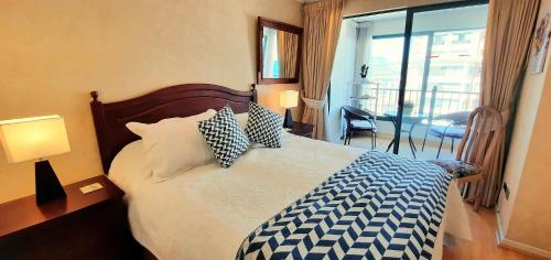 sypialnia z łóżkiem z niebiesko-białymi poduszkami w obiekcie Depto frente a la playa Av Jorge Montt w mieście Viña del Mar