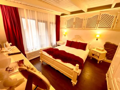 ブラショヴにあるVila Cochetのベッドルーム1室(大型ベッド1台、赤い枕付)