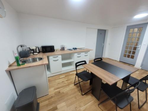 a kitchen with a table and chairs in a room at Appartements à Meaux - Proche de Disney in Meaux