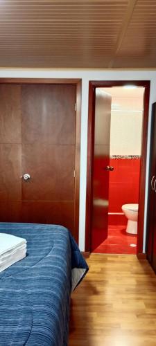 a bedroom with a bed and a bathroom with a toilet at Tranquilo baño privado in Chía