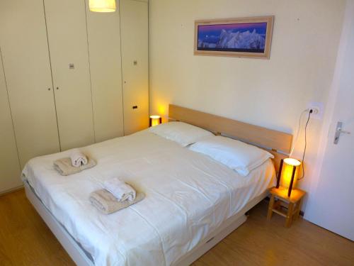 a bedroom with a white bed with towels on it at Apartment Les Choucas B by Interhome in Vermala