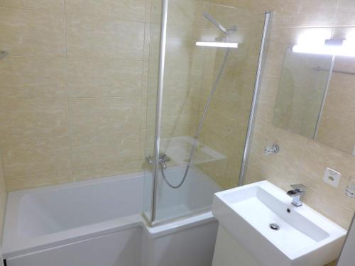 uma casa de banho com um chuveiro, um lavatório e uma banheira em Apartment Les Choucas B by Interhome em Vermala