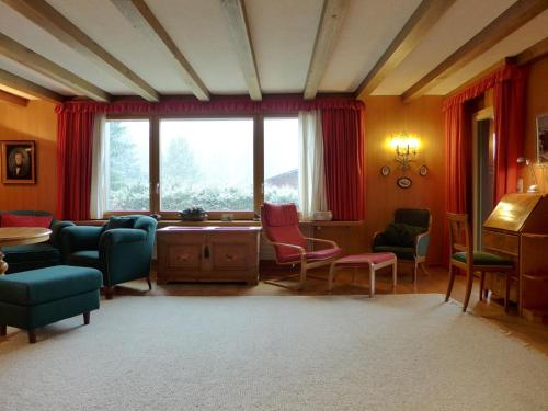 ein Wohnzimmer mit Stühlen, einem Tisch und einem Fenster in der Unterkunft Holiday Home Chalet Marietta by Interhome in Kandersteg