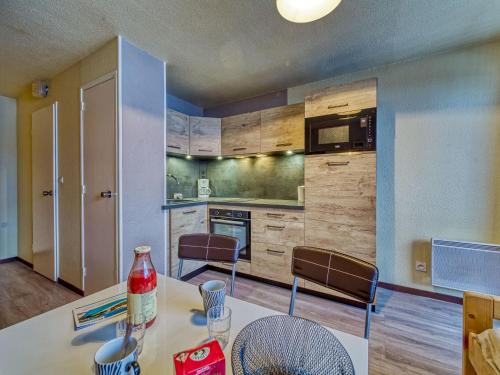 - une cuisine avec une table, des chaises et un comptoir dans l'établissement Apartment Argousier 134 B by Interhome, aux Menuires