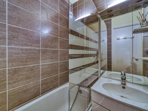 une salle de bain avec un lavabo et une baignoire dans l'établissement Apartment Argousier 134 B by Interhome, aux Menuires